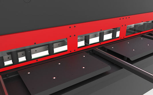 Close-up of the C3006CNC cutting zone with hydraulic hold-downs and machined worktable support spheres