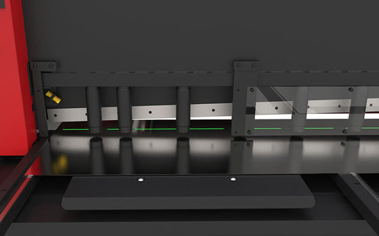 Close-up of the C2006CNC cutting zone showing hydraulic hold-downs and green laser cutting-line indicator
