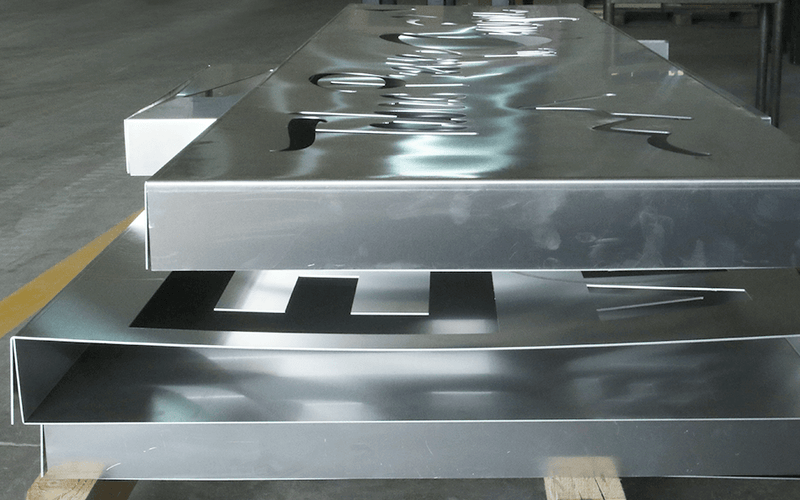 Load image into Gallery viewer, Precision-formed metal panels with laser-cut lettering produced on the Nargesa MP3160CNC press brake

