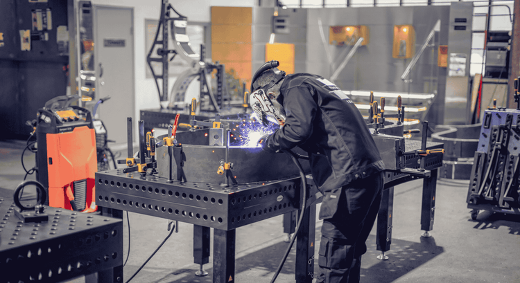 Person welding metal in a workshop setting